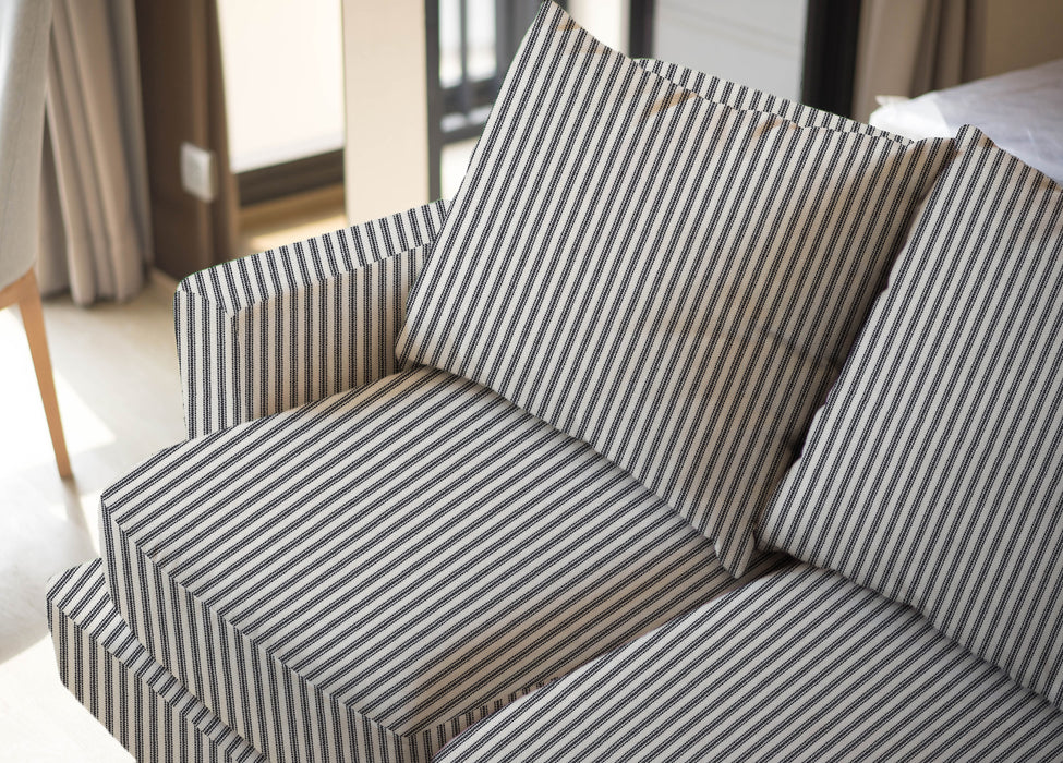 Upholstered sofa shown in Revolution Performance Fabric Foreshore Marine, featuring classic navy and ivory vertical stripes that create a clean, tailored look. The smooth, finely woven texture highlights the subtle contrast between the stripe bands.