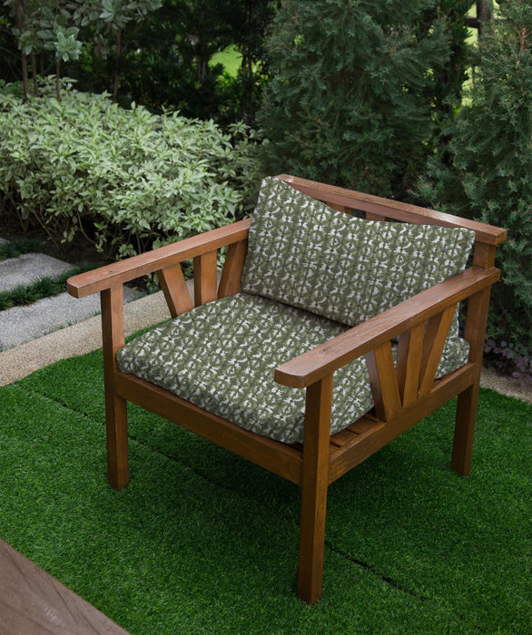 Revolution Performance Fabric outdoor chair cushions in the Polynesian pattern, Green colorway, featuring earthy olive green and ivory abstract geometric motifs upholstered on a wooden armchair for durable, high-performance outdoor seating.